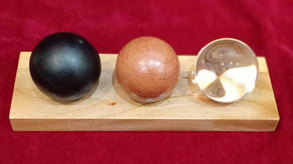 glass, rubber, wood ball on wood base